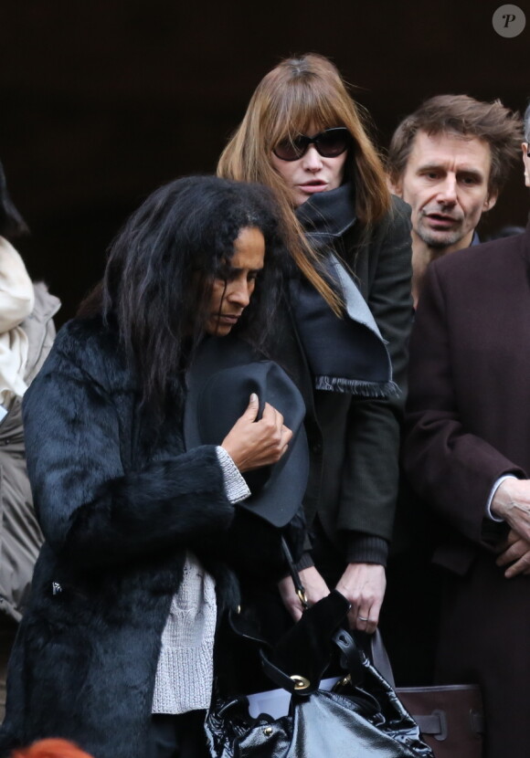 Karine Silla et Carla Bruni-Sarkozy quittant les obsèques de Kate Barry en l'église Saint-Roch à Paris le 19 décembre 2013