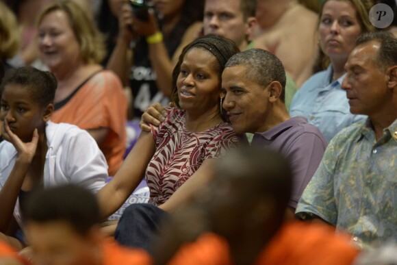 Barack Obama et son épouse, Michelle, assistent à un match de basketball universitaire au Manoa Stan Sheriff Center à Honolulu, le 22 décembre 2013.