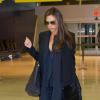 Victoria Beckham, tout de noir vêtue à l'aéroport JFK avec un manteau et un sac de sa marque éponyme, et des bottines Saint Laurent, s'apprête à quitter New York. Le 11 janvier 2014.