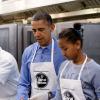 Barack Obama en compagnie de sa fille Sasha au D.C Central Kitchen de Washington lors du Martin Luther King, Jr. Day, préparant des burritos pour la soupe populaire du jour, le 20 janvier 2014, accompagné de son épouse Michelle Obama et leur autre fille Malia