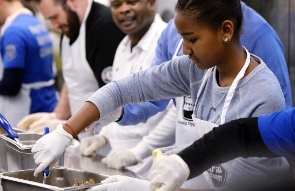 Sasha Obama, très concentrée au D.C Central Kitchen de Washington lors du Martin Luther King, Jr. Day, préparant des burritos pour la soupe populaire du jour, le 20 janvier 2014