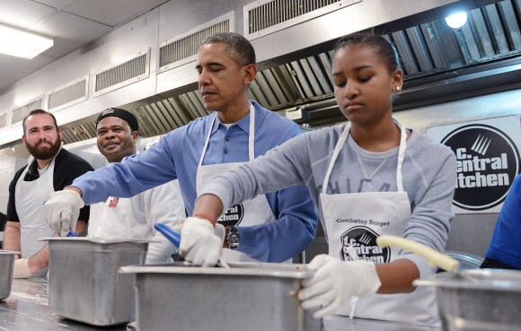 Sasha Obama au D.C Central Kitchen de Washington lors du Martin Luther King, Jr. Day, préparant des burritos pour la soupe populaire du jour, le 20 janvier 2014, sous les yeux de son père Barack