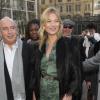 Kate Moss arrive au défilé Topshop Unique avec Sir Philip Green, habillée d'une veste en fourrure, d'une combinaison Topshop et de bottines noires Azzedine Alaïa. Londres, le 16 février 2014.