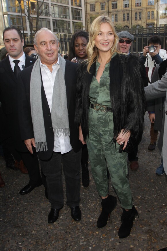 Kate Moss arrive au défilé Topshop Unique avec Sir Philip Green, habillée d'une veste en fourrure, d'une combinaison Topshop et de bottines noires Azzedine Alaïa. Londres, le 16 février 2014.