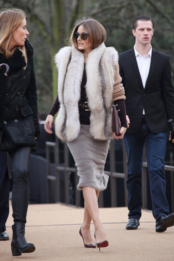 Olivia Palermo arrive au défilé Burberry Prorsum, habillée d'un gilet Salvatore Ferragamo, d'une jupe en fourrure et de souliers Christian Louboutin. Londres, le 17 février 2014.