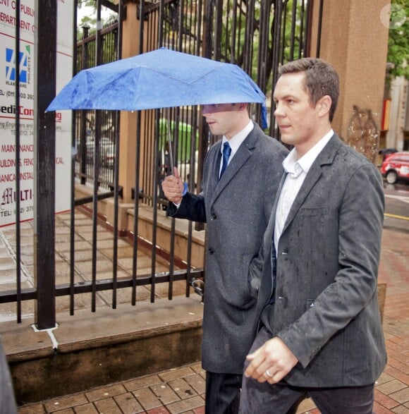 Oscar Pistorius lors de son arrivée sous la pluie au tribunal de Pretoria pour le second jour de son procès, le 4 mars 2014
