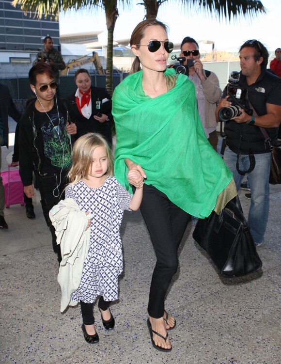 Angelina Jolie arrivant à l'aéroport de Los Angeles en provenance d'Australie avec ses enfants, le 5 février 2014. Elle tient par la main Vivienne