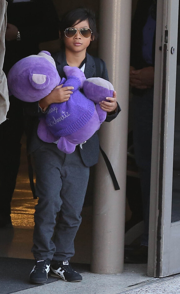 Brad Pitt et Angelina Jolie arrivant à l'aéroport de Los Angeles en provenance d'Australie avec leurs enfants, le 5 février 2014. Pax marche à coté de son père avec son nounours violet