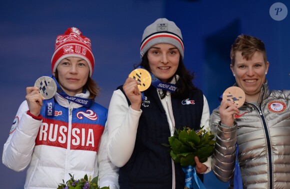 La Russe Inga Medvedeva (médaille d'argent), la Française Marie Bochet (médaille d'or), l'Américaine Allison Jones (médaille de bronze) posent avec leurs médailles penadnt la cérémonie de récompense pour leurs victoires dans la descente de ski féminin aux Jeux Paralympiques d'Hiver à Sotchi, le 9 mars 2014.