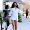 Rihanna en pleine séance shopping à Los Angeles, porte une veste blanche à rayures sans soutien-gorge, un mini-short en jean et des sandales Maolo Blahnik. Le 22 avril 2014.