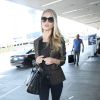 Rosie Huntington-Whiteley, surprise à l'aéroport de Los Angeles pour prendre un vol à destination de New York, porte un sac Saint Laurent et des bottines Balmain. Le 24 avril 2014.