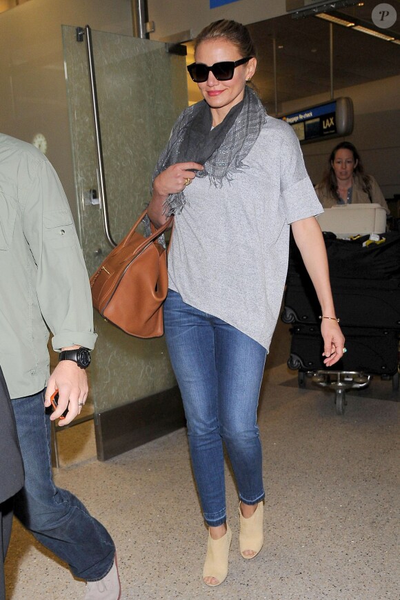 Cameron Diaz arrive à l'aéroport de Los Angeles, habillée d'un t-shirt gris, d'un jean Stella McCartney, d'un sac Céline et de bottines Maison Martin Margiela. Le 18 avril 2014.