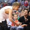 Justin Bieber salue Mark Wahlberg et son épouse lors du match de basket opposant les Clippers de Los Angeles aux Thunder d'Oklahoma City, au Staples Center à L.A., le 11 mai 2014.