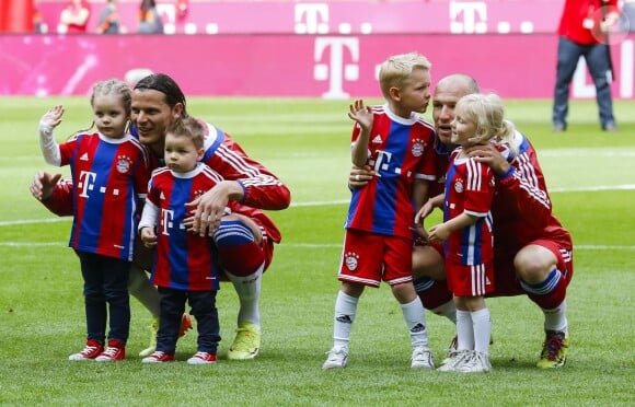 Daniel Van Buyten avec Lou-Ann et Lee-Roy, et Arjen Robben avec Luka et Lynn, leurs enfants respectifs, fêtent le titre de champion d'Allemagne du Bayern Munich avec leurs enfants le 10 mai 2014. 