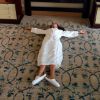 Victoria Beckham, en robe de chambre et pantoufles, allongée dans sa chambre d'hôtel de Singapour.