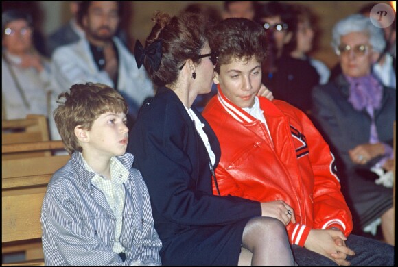 Véronique Colucci et ses fils, Marius et Romain, le jour de l'enterrement de Coluche le 24 juin 1986. 