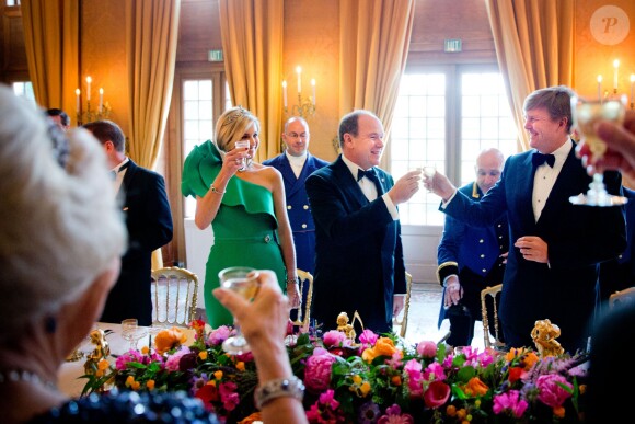 Le prince Albert II de Monaco et ses hôtes le roi Willem-Alexander et la reine Maxima des Pays-Bas trinquent à sa future paternité, au palais Het Loo à Apeldoorn le 3 juin 2014. La princesse Charlene, enceinte, s'était désistée de cette visite officielle, trois jours après l'annonce de sa grossesse.