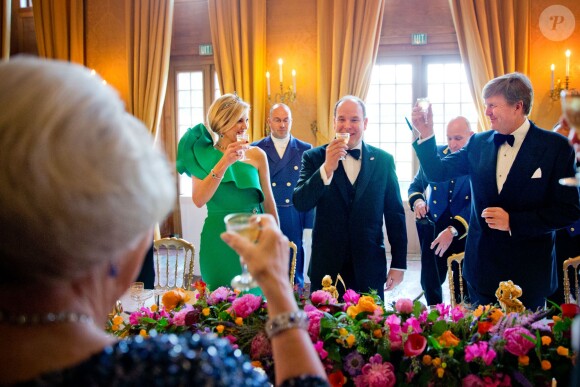 Le prince Albert II de Monaco et ses hôtes le roi Willem-Alexander et la reine Maxima des Pays-Bas trinquent à sa future paternité, au palais Het Loo à Apeldoorn le 3 juin 2014. La princesse Charlene, enceinte, s'était désistée de cette visite officielle, trois jours après l'annonce de sa grossesse.
