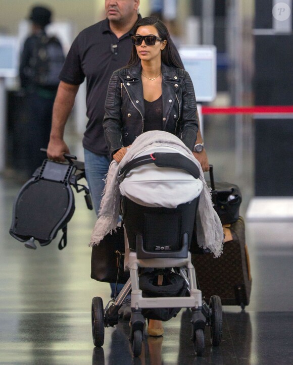 Kim Kardashian et sa fille North West arrivent à l'aéroport de New York, le 25 juin 2014.