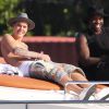 Justin Bieber se relaxe sur un yacht avec des amis à Miami, le 3 juillet 2014. Le jeune chanteur boit une bière assis sur l'avant du bateau. 