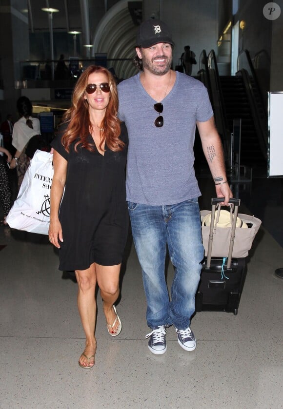 Poppy Montgomery et son mari Shawn Sanford à l'aéroport de Los Angeles, le 3 juillet 2014.