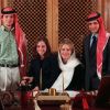 Les princes Hashem et Hamzah de Jordanie en 1999 avec leur soeur la princesse Iman et leur mère la reine Noor, posant dans le bureau du regretté roi Hussein après sa mort.