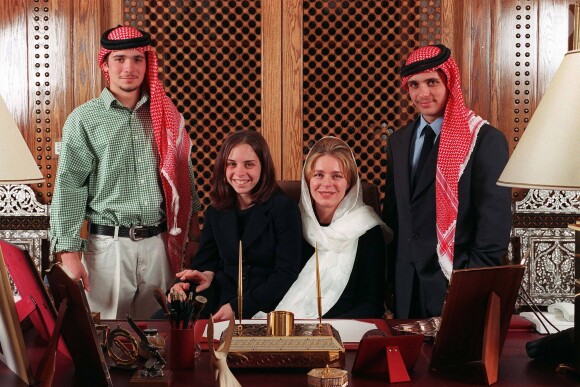 Les princes Hashem et Hamzah de Jordanie en 1999 avec leur soeur la princesse Iman et leur mère la reine Noor, posant dans le bureau du regretté roi Hussein après sa mort.