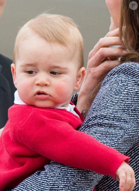 Le prince William, Kate Middleton la duchesse de Cambridge et leur fils George montent à bord d'un avion pour rentrer à Londres après leur visite officielle en Australie, le 25 avril 2014.