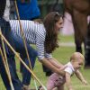 Le prince George de Cambridge tente d'échapper à la vigilance de sa mère Kate Middleton le 15 juin 2014 lors d'un match de polo (Jerudong Trophy) joué par les princes William et Harry à Cirencester.