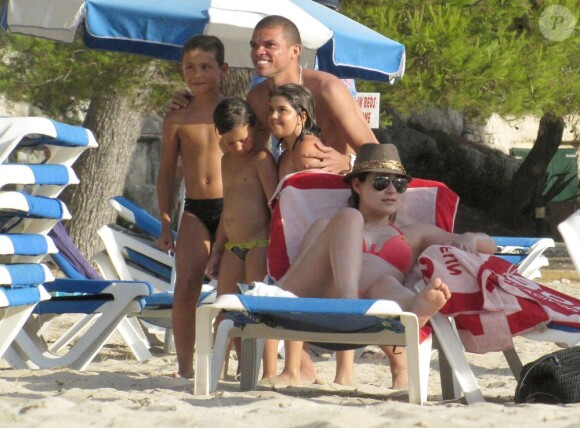 Képler Laveran Lima Ferreira dit Pepe prend la pose avec de jeunes fans devant sa compagne Ana Sofia le 7 juillet 2012 sur l'île de Minorque avant la naissance de leur premier enfant prévue pour la fin de l'été