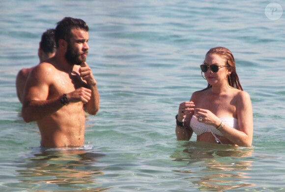 Lindsay Lohan profite de ses vacances avec un mystérieux inconnu sur une plage de l'île de Mykonos, le 5 août 2014.