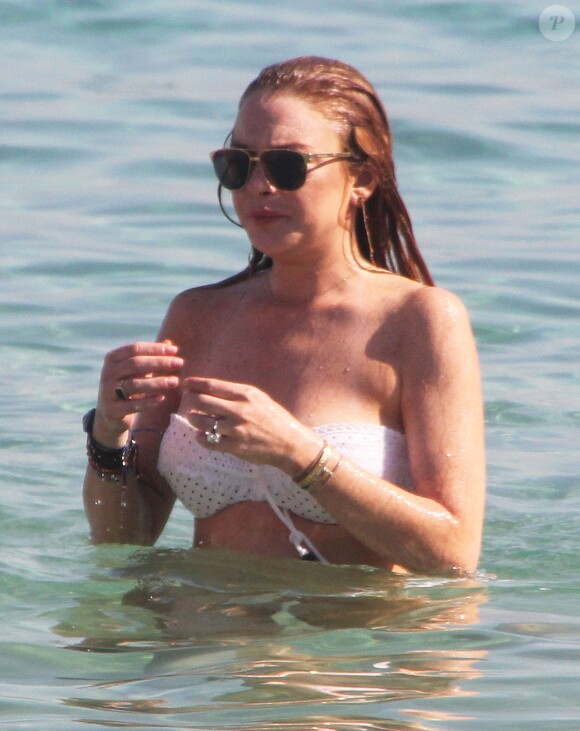 Lindsay Lohan profite de ses vacances avec un mystérieux inconnu sur une plage de l'île de Mykonos, le 5 août 2014.