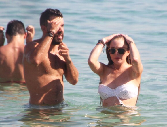 Lindsay Lohan profite de ses vacances avec un mystérieux inconnu sur une plage de l'île de Mykonos, le 5 août 2014.