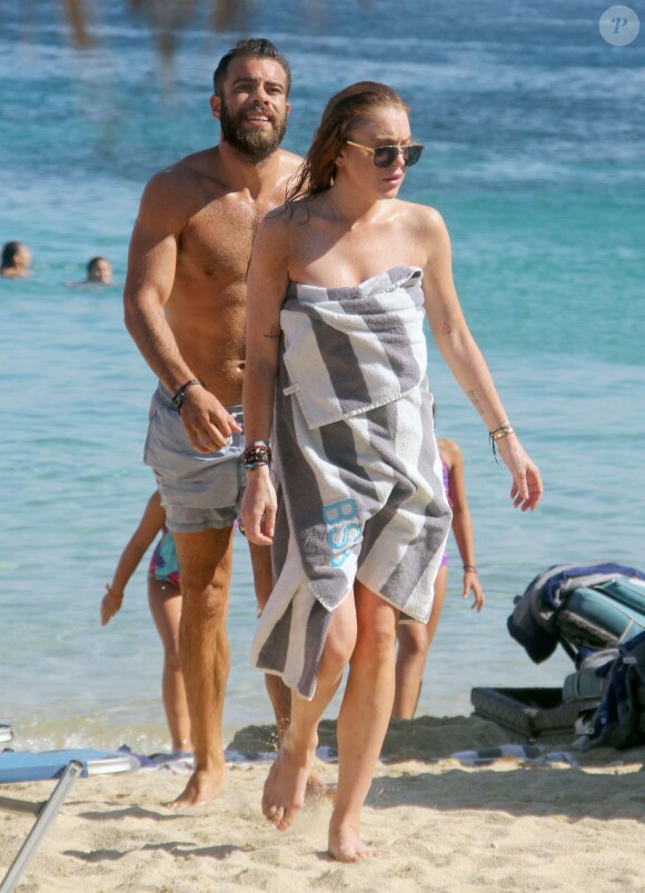 Lindsay Lohan profite de ses vacances avec un mystérieux inconnu sur une plage de l'île de Mykonos, le 5 août 2014.