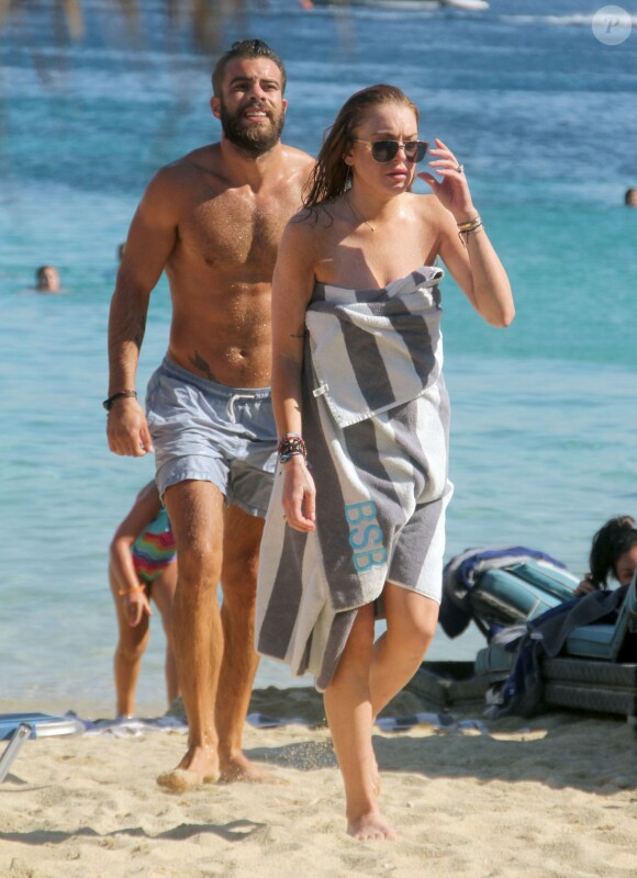 Lindsay Lohan profite de ses vacances avec un mystérieux inconnu sur une plage de l'île de Mykonos, le 5 août 2014.