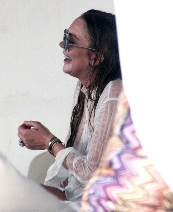 Lindsay Lohan profite de ses vacances avec un mystérieux inconnu sur une plage de l'île de Mykonos, le 5 août 2014.