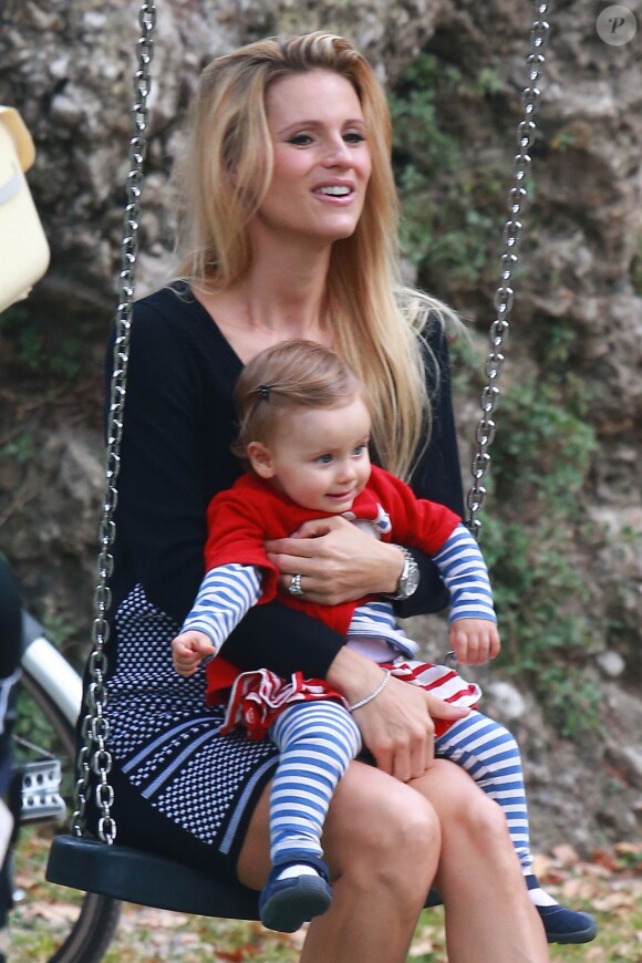 Michelle Hunziker, enceinte, avec sa fille Sole, heureuse sur une balançoire dans un parc à Milan le 30 septembre 2014.