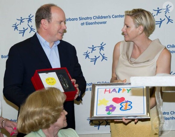 La princesse Charlene de Monaco, enceinte de jumeaux, et le prince Albert II de Monaco ont visité le 11 octobre 2014 le Barbara Sinatra Children's Center au profit des enfants défavorisés, et y ont reçu de touchants cadeaux.