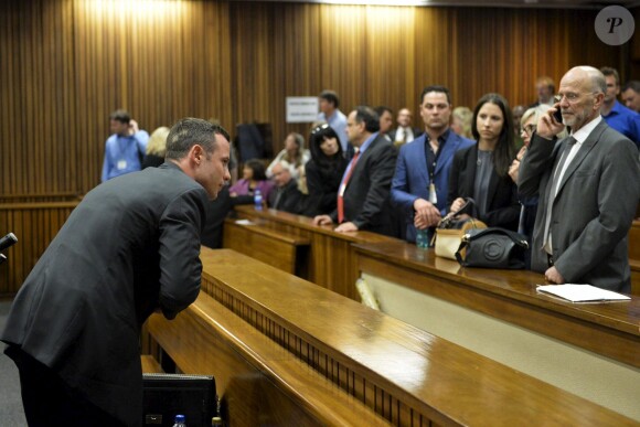 Oscar Pistorius devant son oncle Arnold, sa soeur Aimee et son frère Carl au tribunal de Pretoria, le 3 mars 2014