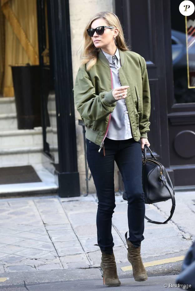 Kate Moss quitte l'hôtel Costes à Paris, habillée d'un bomber réversible kaki et rose, d'une chemise, d'un jean noir rag & bone et de bottines Alaïa. Des lunettes de soleil et un sac Saint Laurent accessoirisent sa tenue. Le 6 novembre 2014.
