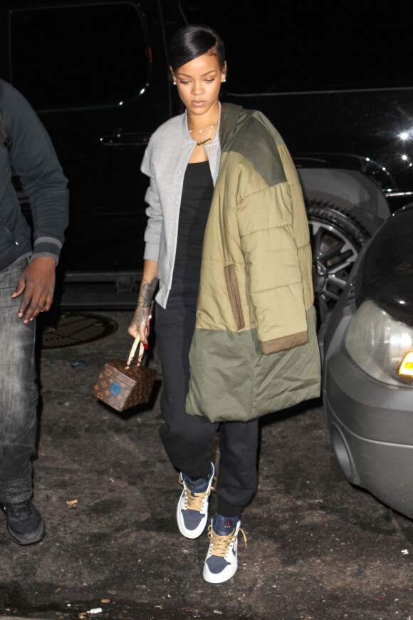 Rihanna se rend dans un studio d'enregistrement à New York, et porte une veste T by Alexander Wang, un manteau kaki Isabel Marant Etoile, un sac Louis Vuitton, un jogging et des baskets Nike Air Jordan 1 (modèle Phat Olympic). Le 4 novembre 2014.