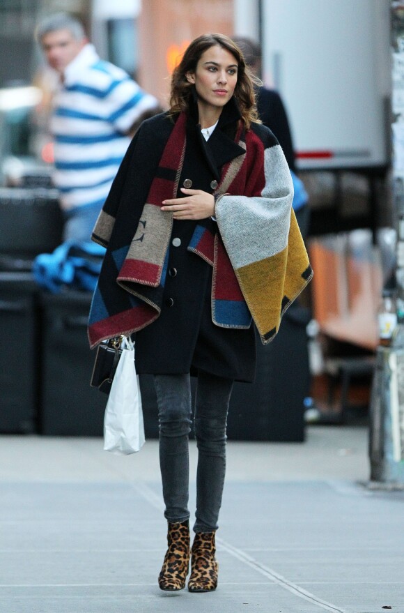 Alexa Chung se promène dans les rues de New York, habillée d'un poncho Burberry Prorsum, d'un manteau et d'un pantalon noir, et de bottines au motif léopard. Le 3 novembre 2014.
