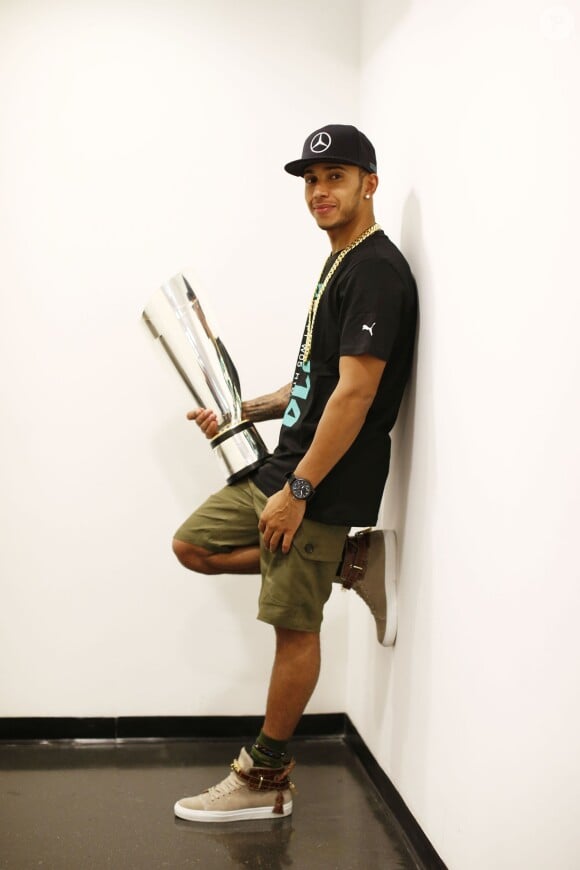 Lewis Hamilton prend la pose avec son trophée de champion du monde, le 24 novembre 2014 à Abou Dhabi