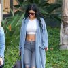 Kylie Jenner surprise à Calabasas, porte un manteau bleu ciel Asos, un crop top blanc, un jean J Brand, un sac Givenchy (modèle Antigona) et des chaussures Gianvito Rossi. Los Angeles, le 15 décembre 2014.