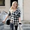 Hilary Duff de sortie à Beverly Hills, Los Angeles, porte une chemise à carreaux, un sac Chanel, un jean noir et des bottines Iro (modèle Kasey). Le 23 décembre 2014.