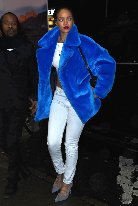 Rihanna, habillée d'un manteau en fourrure bleu Kye (collection automne-hiver 2014), d'un crop top blanc, d'un jean Isabel Marant Etoile, de chaussures Manolo Blahnik et d'un sac à dos Diesel (modèle Karola), se rend dans un magasin Toys"R"Us. New York, le 23 décembre 2014.