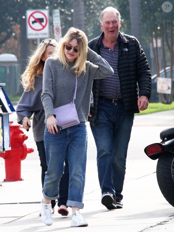 Exclusif - Dakota Fanning promène son chien avec son père Stephen à Los Angeles, habillée d'un pull gris, d'un sac lavande Céline (modèle Trio), d'un jean "boyfriend" et de baskets adidas Originals (modèle Stan Smith). Le 21 décembre 2014.