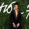 Rihanna assiste aux The British Fashion Awards 2014 à Londres, habillée d'un blazer Stella McCartney, d'un collier et de sandales Giuseppe Zanotti, et de collants noirs. Le 1er décembre 2014.
