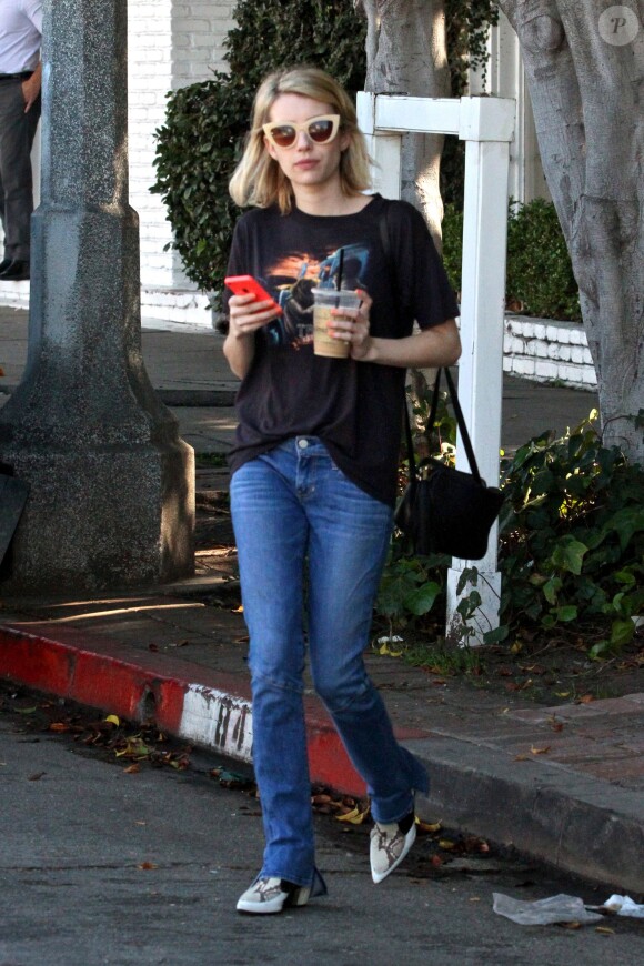 Emma Roberts de sortie à West Hollywood, Los Angeles, porte avec son t-shirt vintage et son jean évasé un sac Gucci (modèle Soho) et des bottines Rodarte (collection printemps-été 2014). Le 9 février 2015.