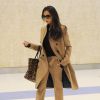 Victoria Beckham surprise à l'aéroport JFK à New York, porte un manteau camel et un pantalon Lanvin assorti, un sac léopard Victoria Beckham (modèle Simple Shopper) et des souliers Nicolas Kirkwood. Le 9 février 2015.